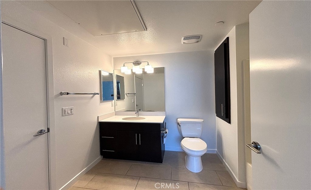 612 East Carson Street, Unit 303 Carson, CA 90745 - Photo 21 of 51 a bathroom with a toilet a sink and a mirror