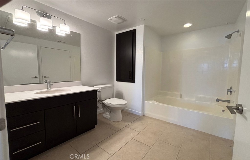 612 East Carson Street, Unit 303 Carson, CA 90745 - Photo 22 of 51 a bathroom with a bathtub shower sink double vanity and toilet