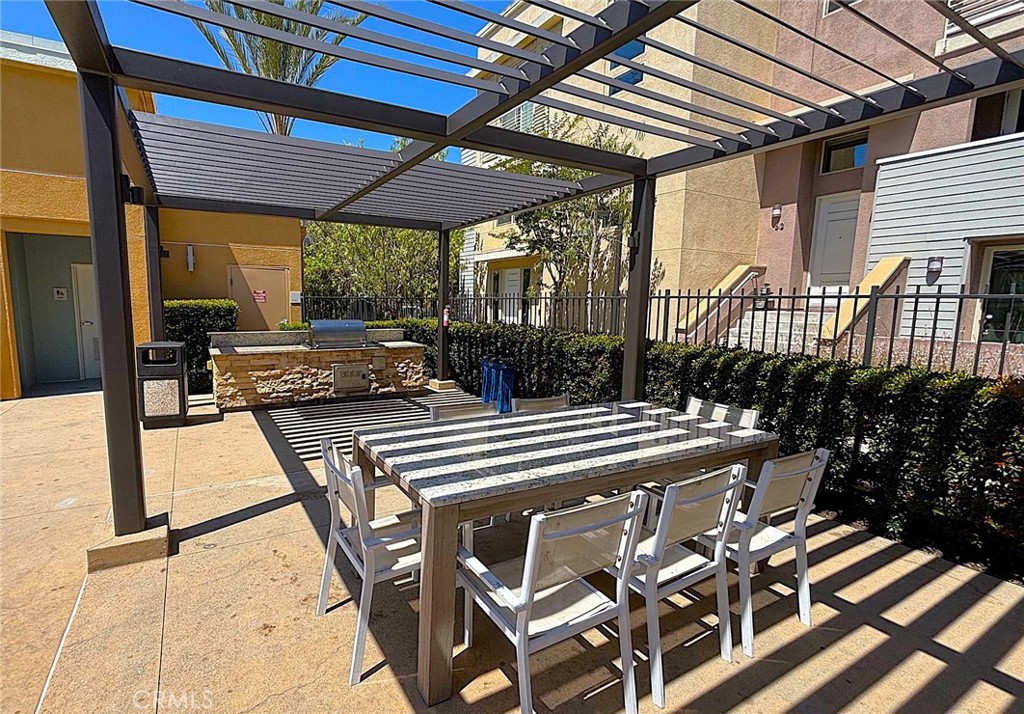 612 East Carson Street, Unit 303 Carson, CA 90745 - Photo 34 of 51 a view of a patio with table and chairs potted plants with wooden floor and fence