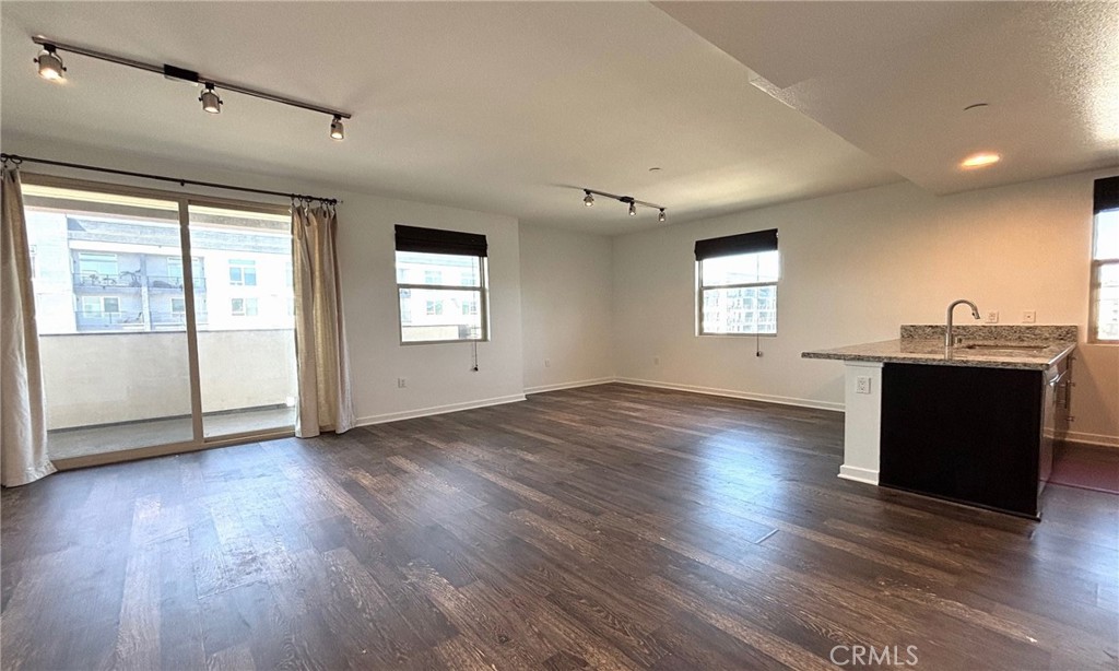 612 East Carson Street, Unit 303 Carson, CA 90745 - Photo 10 of 51 an empty room with wooden floor and windows