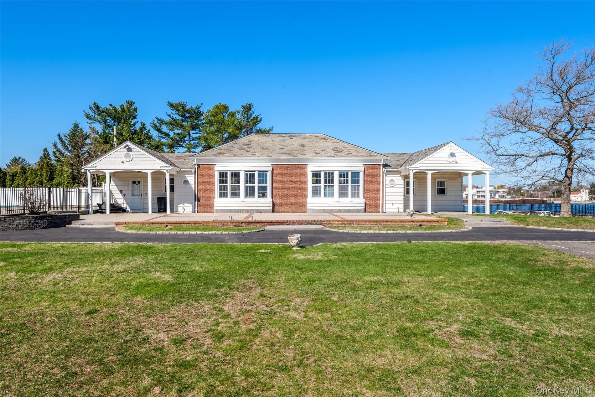 33 Harbour Road Great Neck, NY 11024 - Photo 9 of 14 a front view of a house with a garden