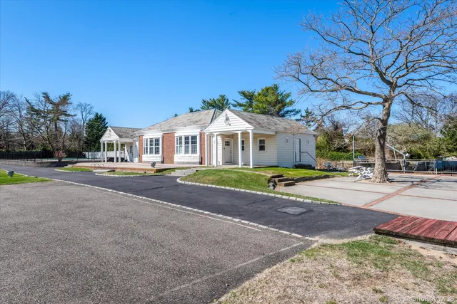 a view of a house with a big yard and large trees