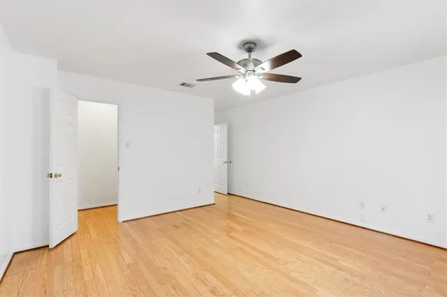 an empty room with windows and fan