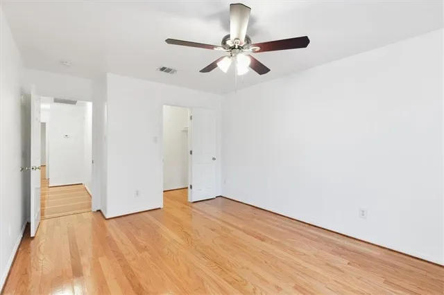 an empty room with a window and a ceiling fan