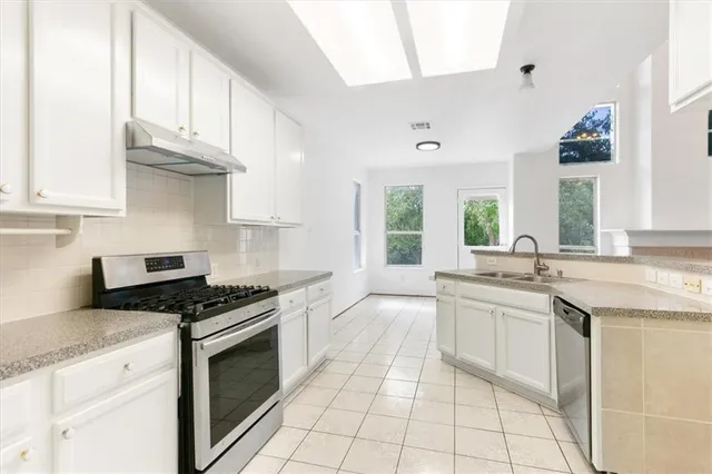 a kitchen with granite countertop a sink stove and cabinets