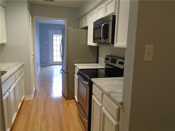 a kitchen with a sink a microwave and cabinets