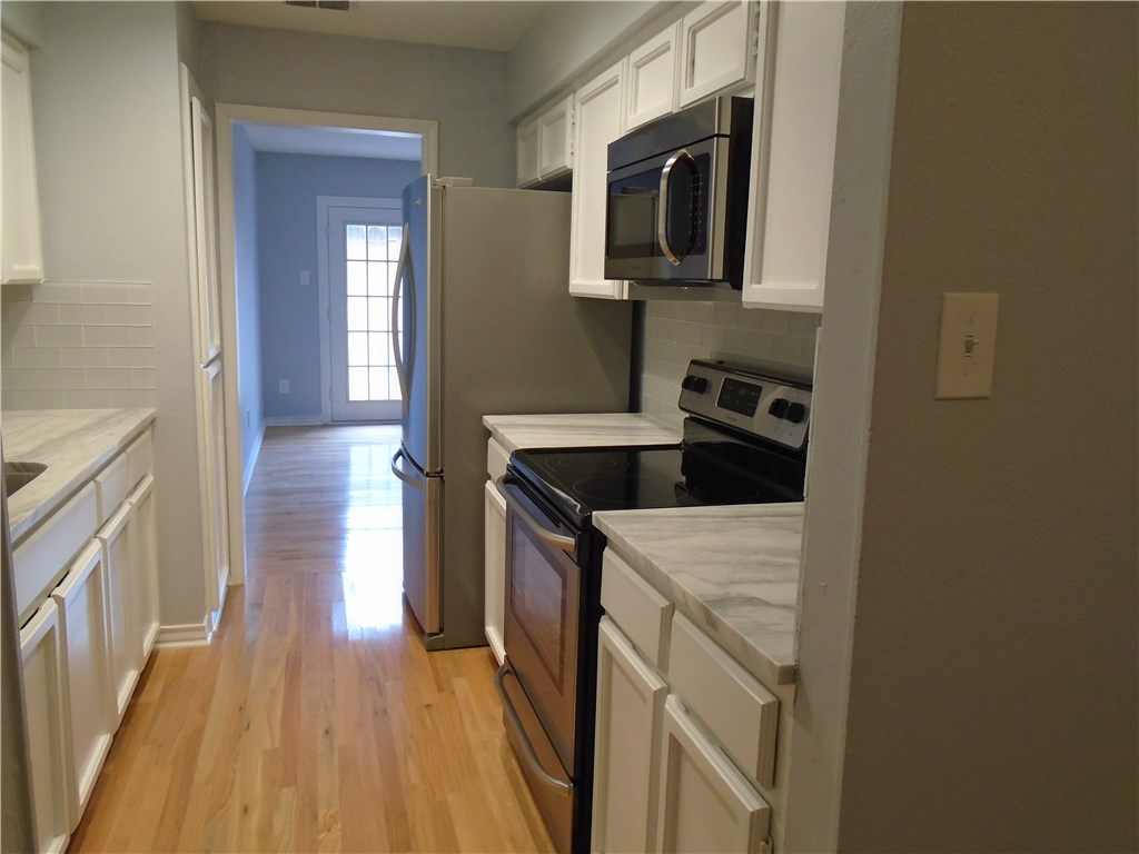 5338 Meadowgate Drive Corpus Christi, TX 78413 - Photo 3 of 15 a kitchen with a sink a microwave and cabinets