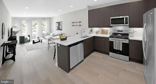 a kitchen with stainless steel appliances a stove a sink a microwave a refrigerator and cabinets