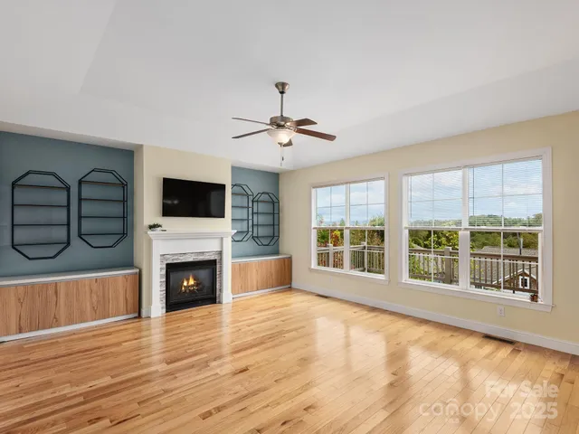 a view of an empty room with a fireplace and a window