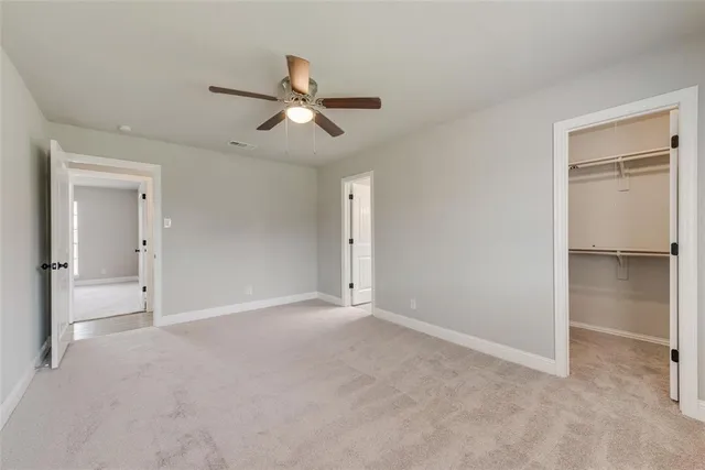 a view of an empty room and a ceiling fan