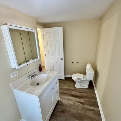 a bathroom with a sink and mirror with toilet