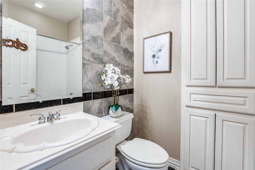 3752 Park Place Addison, TX 75001 - Photo 19 of 25 Bathroom featuring a vanity with an oval sink and a chrome faucet, complemented by a mirror