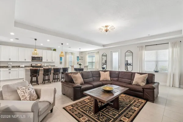 a kitchen with stainless steel appliances a dining table chairs stove and refrigerator