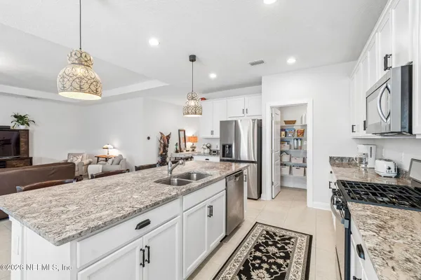 a kitchen with granite countertop a sink stove and cabinets