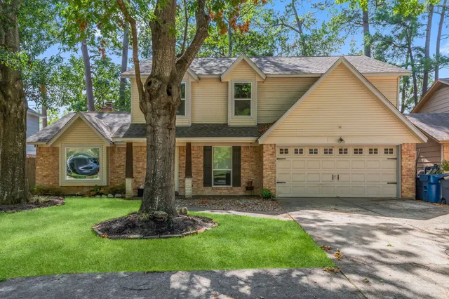 a view of a house with a yard and tree