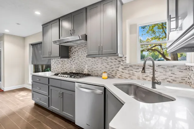 a kitchen with stainless steel appliances granite countertop a sink stove and cabinets