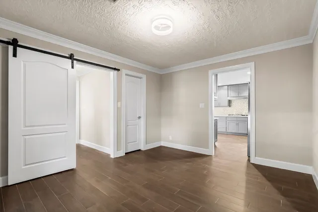 a view of empty room with wooden floor
