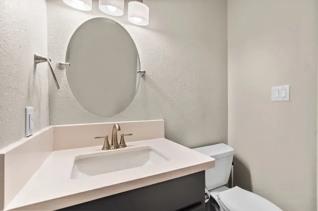 a bathroom with a sink a toilet and a mirror