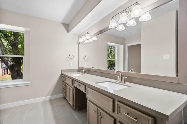 a spacious bathroom with a granite countertop sink a large mirror and a