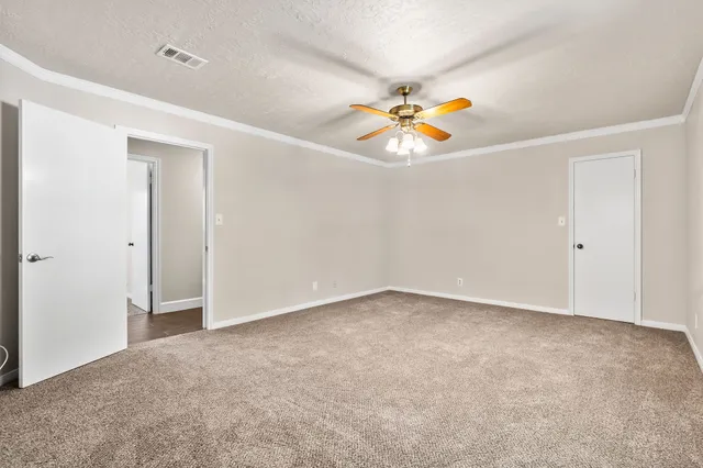an empty room with a ceiling fan and a window