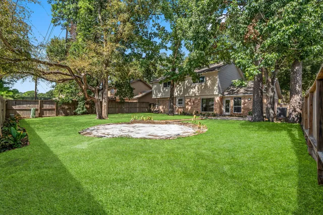 a view of a house with a big yard and large trees