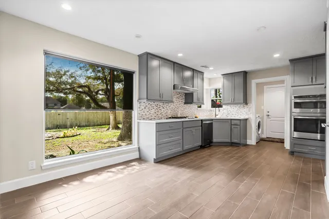 a large white kitchen with a large window