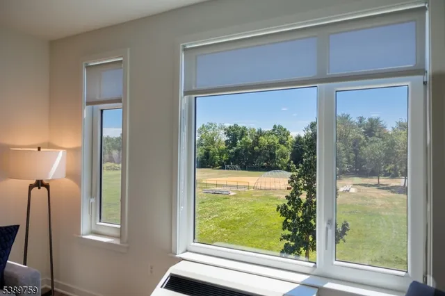 a view of a room that has a large window and front door