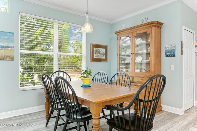 a view of a a dining room with furniture window and wooden floor