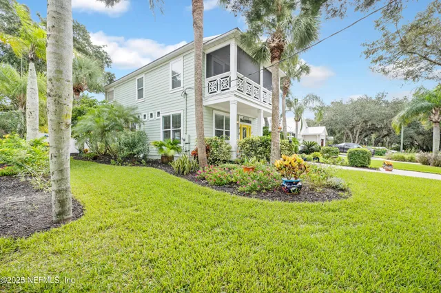 a view of a house with a big yard and large trees