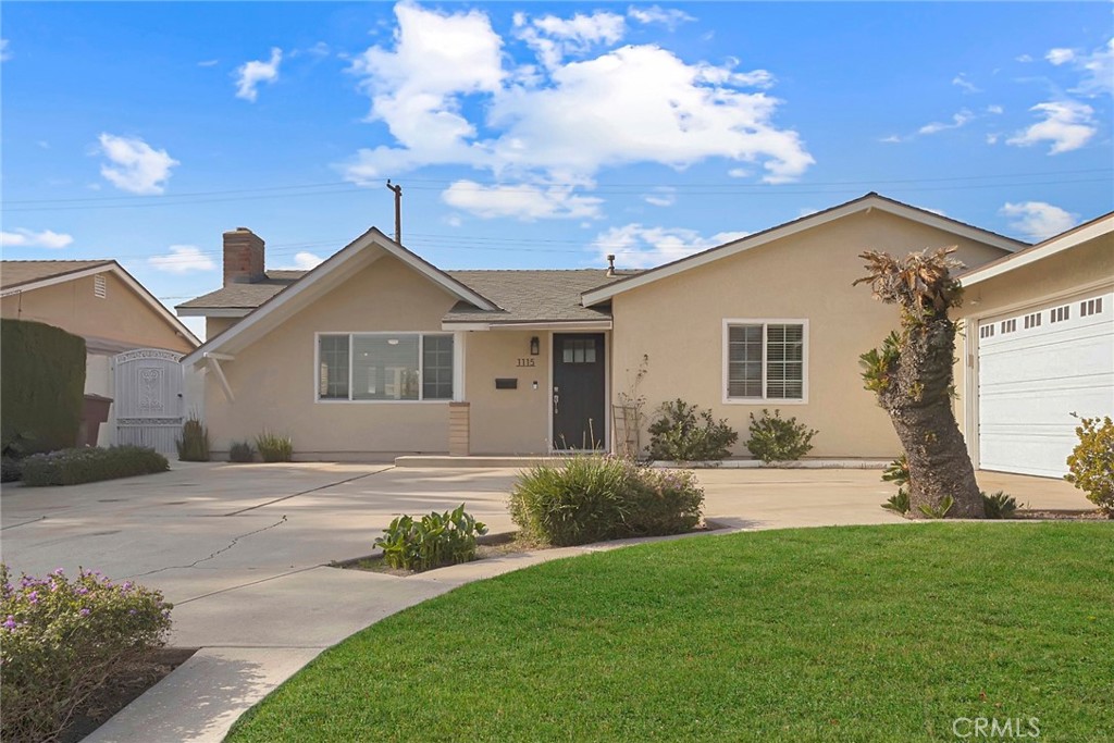 1115 South Groveland Place Anaheim, CA 92806 - Photo 1 of 42 a front view of a house with a garden and yard