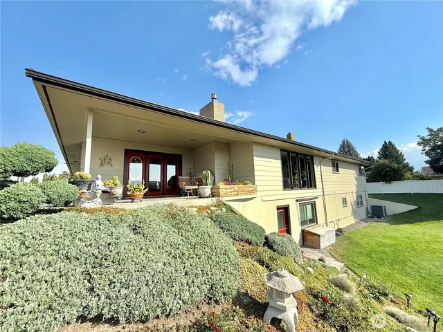a view of a house with backyard and sitting area