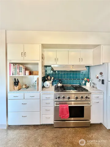 a kitchen with stainless steel appliances granite countertop a stove and a cabinets