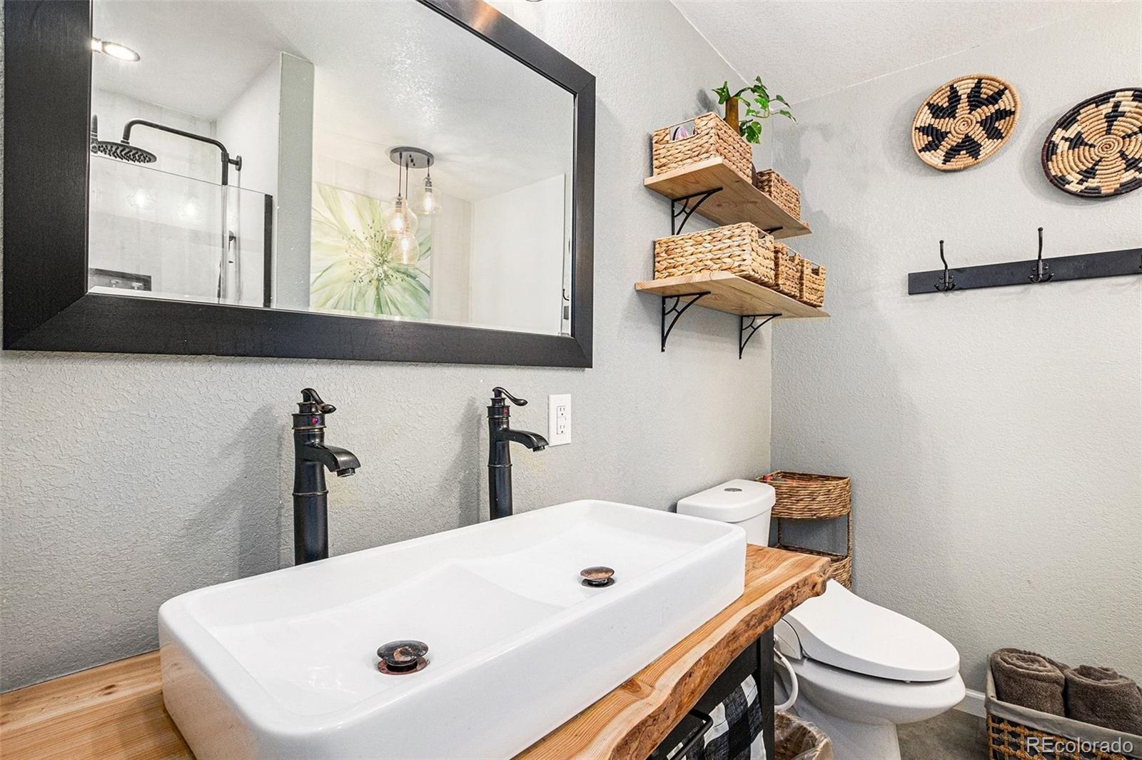 10148 South Turkey Creek Road Morrison, CO 80465 - Photo 15 of 50 a bathroom with a toilet a sink and mirror