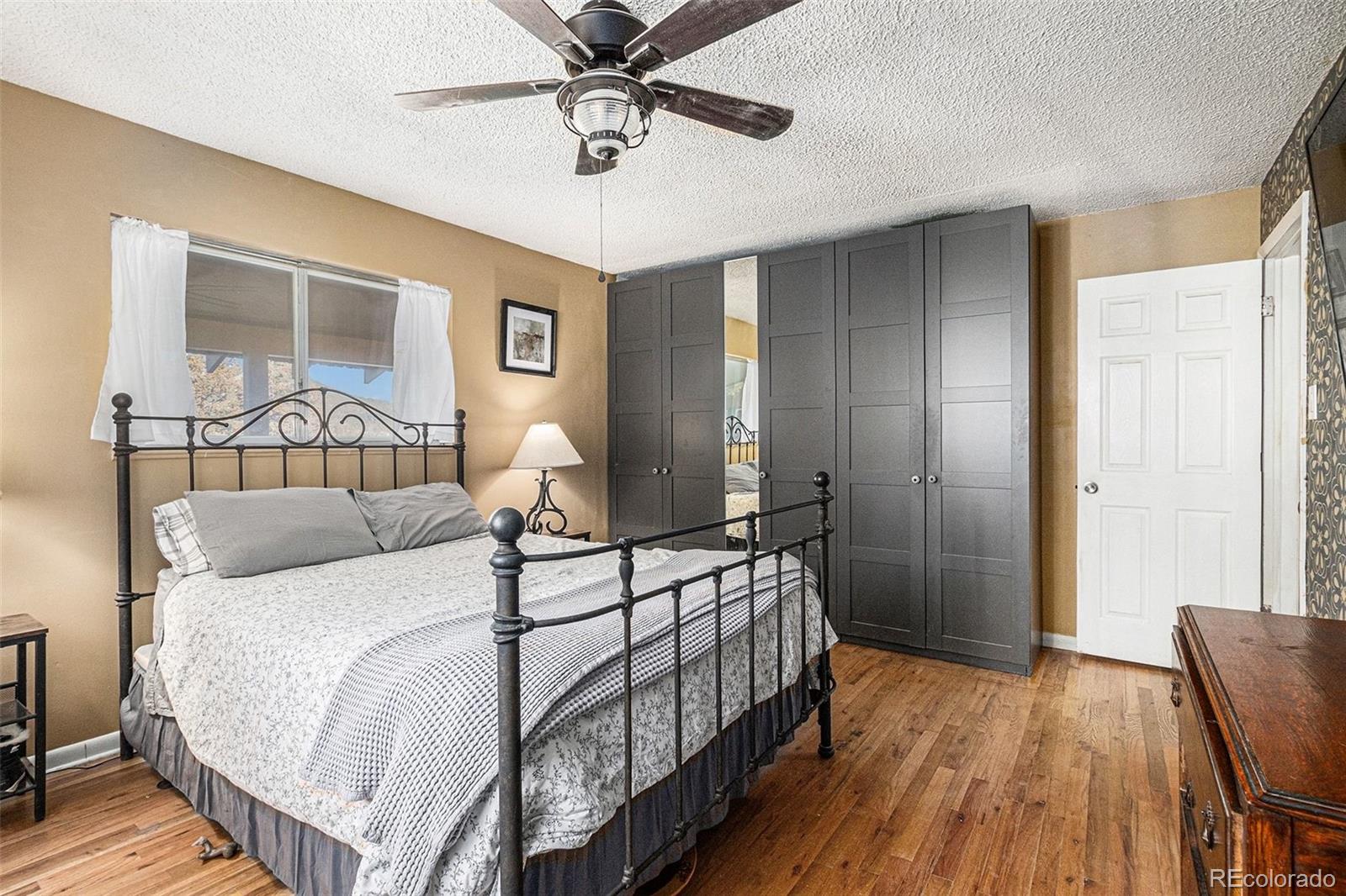 10148 South Turkey Creek Road Morrison, CO 80465 - Photo 17 of 50 a bedroom with a bed and wooden floor