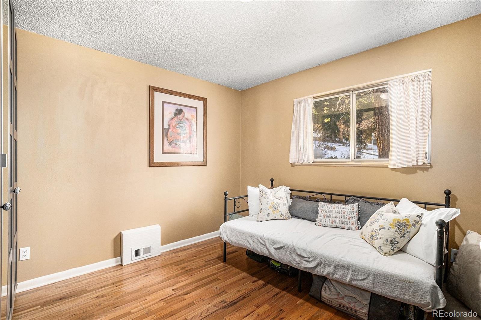 10148 South Turkey Creek Road Morrison, CO 80465 - Photo 18 of 50 a bedroom with a bed and wooden floor