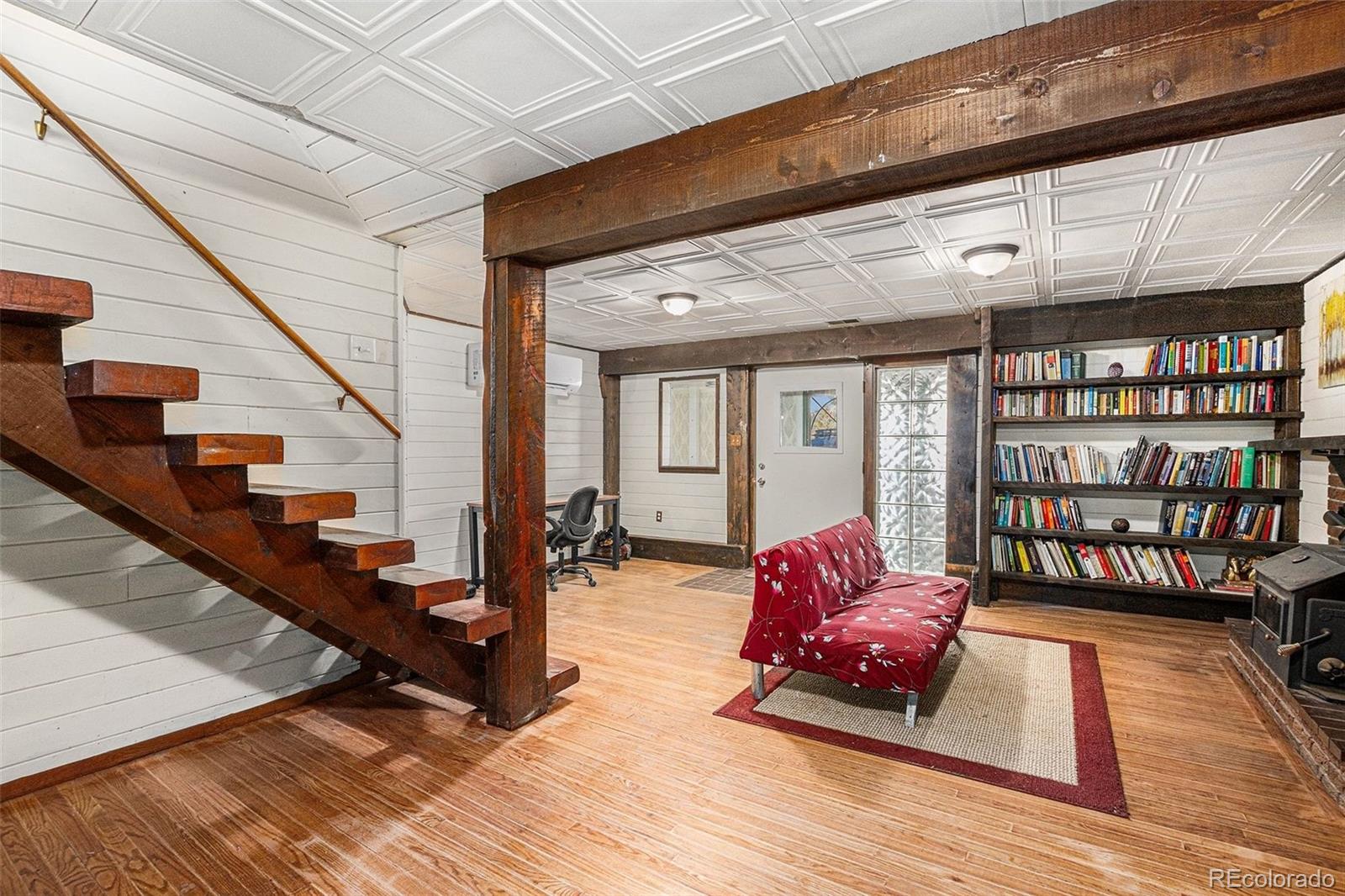 10148 South Turkey Creek Road Morrison, CO 80465 - Photo 19 of 50 a living room with furniture or book shelf and wooden floor
