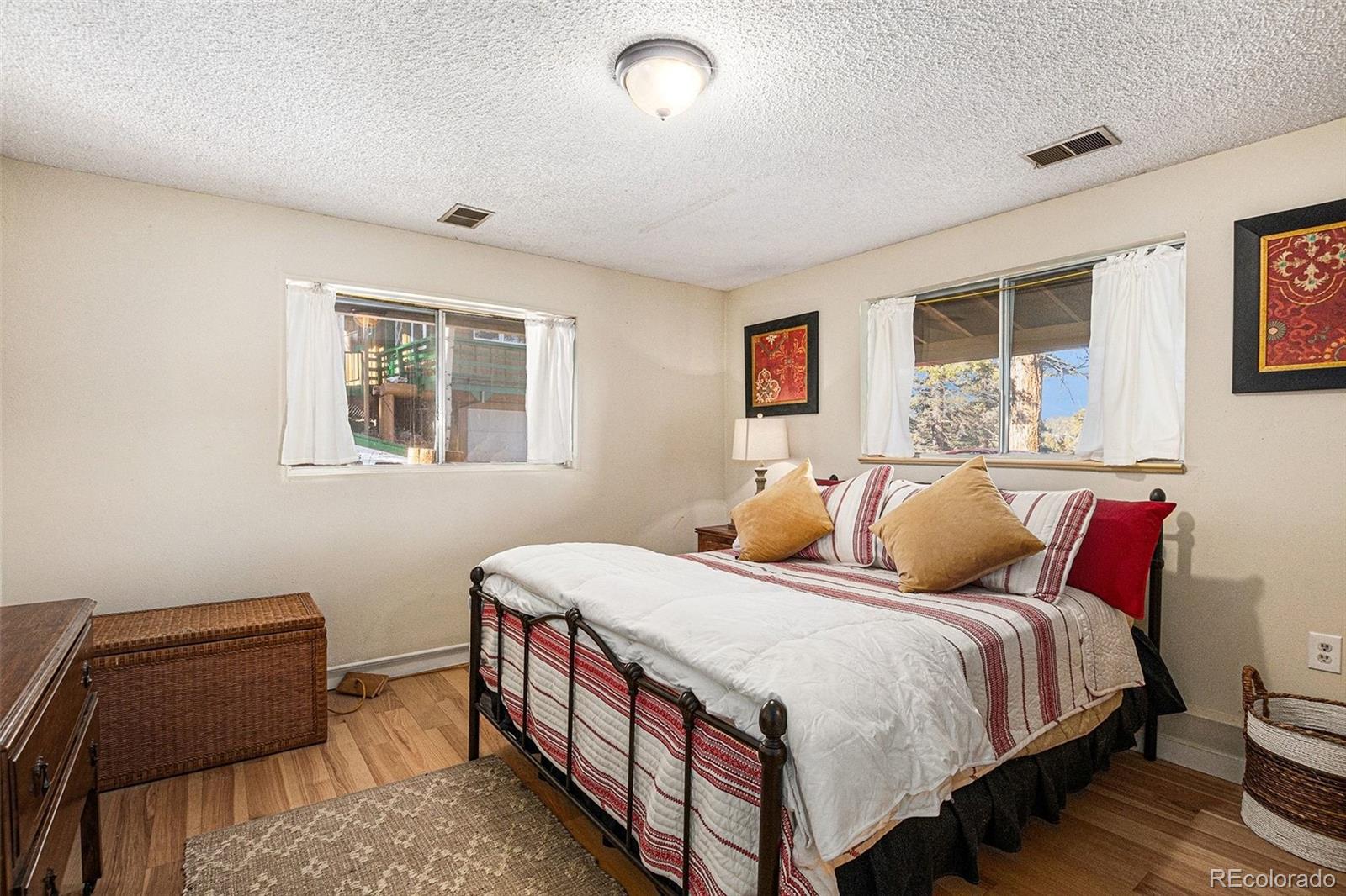 10148 South Turkey Creek Road Morrison, CO 80465 - Photo 21 of 50 a bedroom with a bed and wooden floor