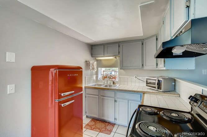 10148 South Turkey Creek Road Morrison, CO 80465 - Photo 32 of 50 a kitchen with a sink a refrigerator and cabinets