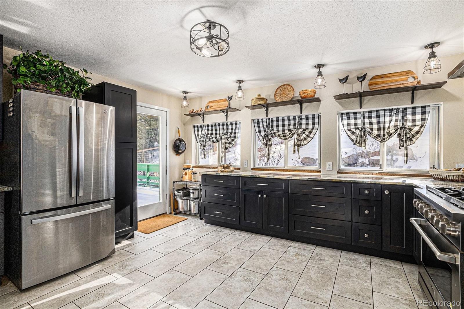 10148 South Turkey Creek Road Morrison, CO 80465 - Photo 6 of 50 a kitchen with a refrigerator and a stove top oven