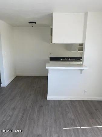 a kitchen with granite countertop a sink and a stove top oven