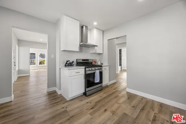 a kitchen with granite countertop a stove top oven and cabinets