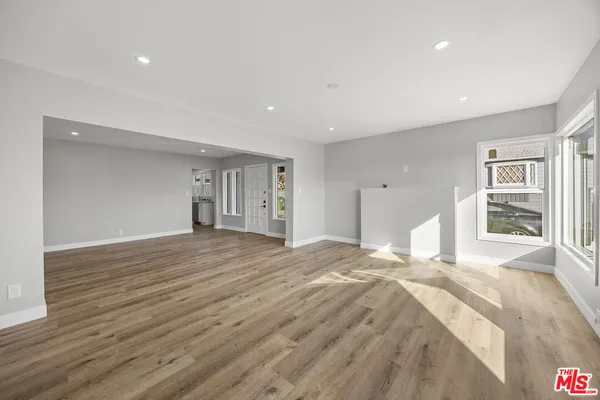 a large bedroom with a bed and wooden floor