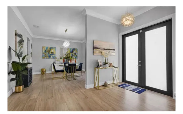 a kitchen with stainless steel appliances kitchen island granite countertop a dining table chairs and white cabinets