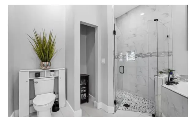 a view of a white house with a big yard plants and large trees