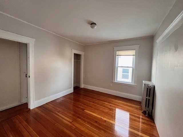 81 Pleasant Street, Unit 3 Boston, MA 02125 - Photo 16 of 21 a view of an empty room with wooden floor and a window