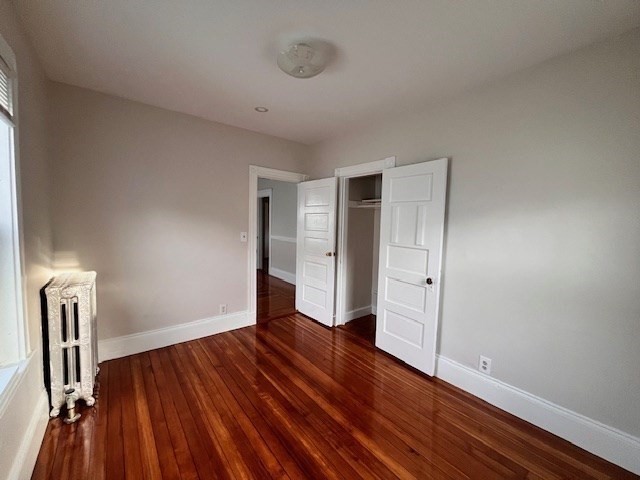 81 Pleasant Street, Unit 3 Boston, MA 02125 - Photo 18 of 21 a view of an empty room with wooden floor and a window