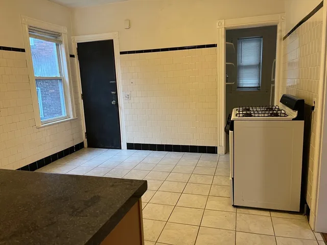 a view of a kitchen with wooden floor and a refrigerator