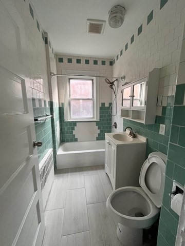 81 Pleasant Street, Unit 3 Boston, MA 02125 - Photo 5 of 21 a bathroom with a sink toilet a mirror and bathtub