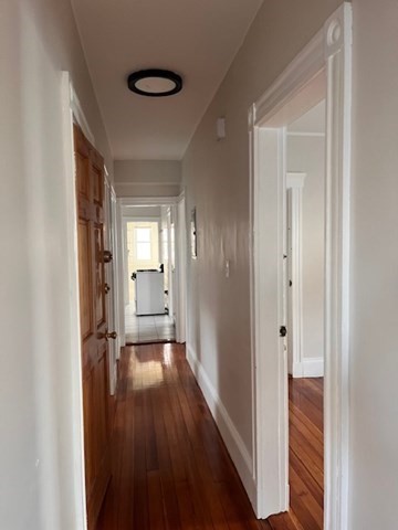 81 Pleasant Street, Unit 3 Boston, MA 02125 - Photo 9 of 21 a view of a hallway with wooden floor and furniture