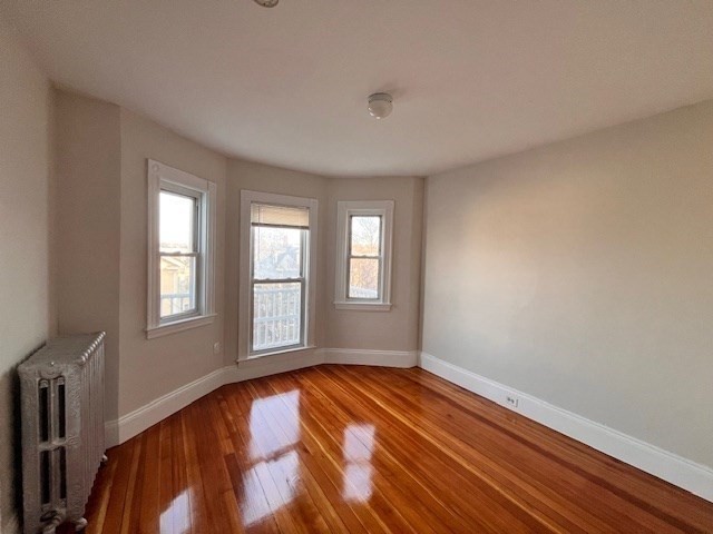 81 Pleasant Street, Unit 3 Boston, MA 02125 - Photo 10 of 21 a view of empty room with wooden floor and fan